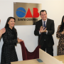 Foto mostra uma placa da OAB/SC com o presidente do TCE/SC, Adircélio de Moraes, e a presidente da OAB/SC, Cláudia Prudêncio, sorrindo em frente à placa.